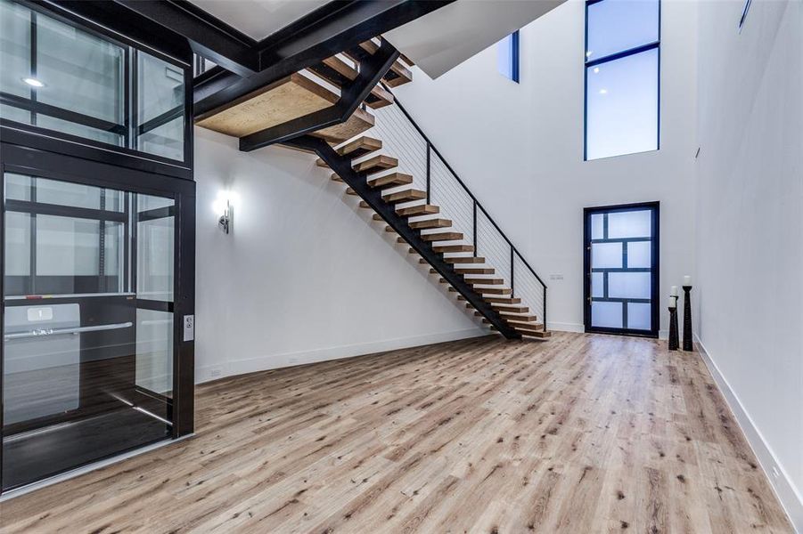 Entryway with a towering ceiling and light hardwood / wood-style floors