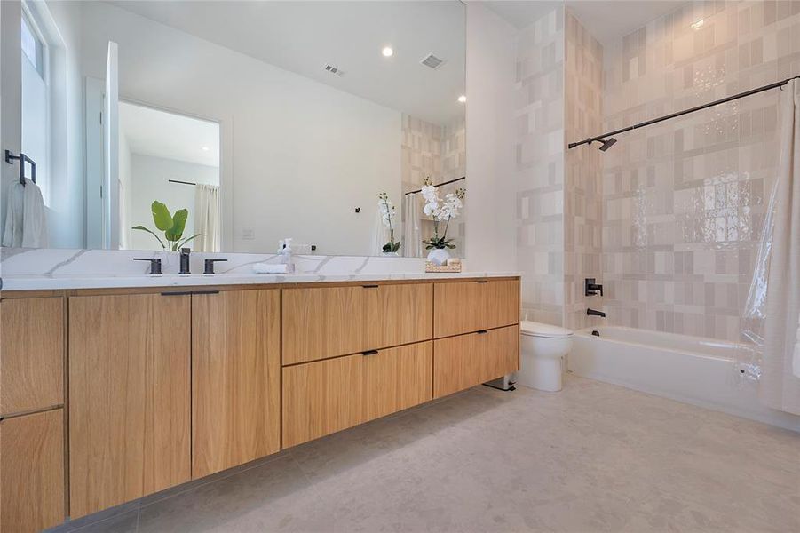 Full bathroom featuring vanity, shower / tub combo, and toilet