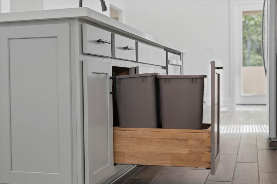 Smart storage solutions include a convenient pull-out trash and recycling center built directly into the island. Smart storage solutions include a convenient pull-out trash and recycling center built directly into the island.