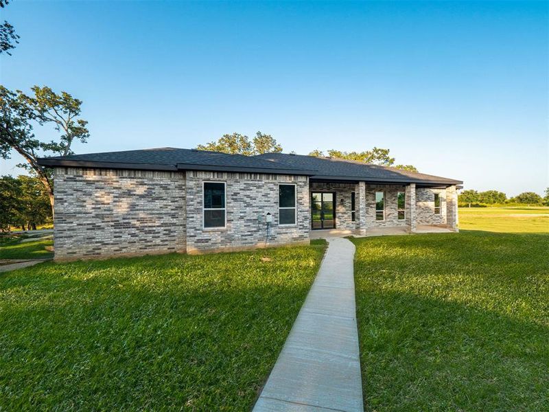 View of front of home featuring a patio and a front lawn