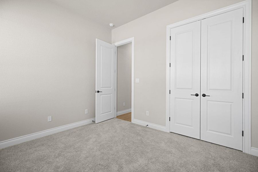 Unfurnished bedroom with light carpet and a closet