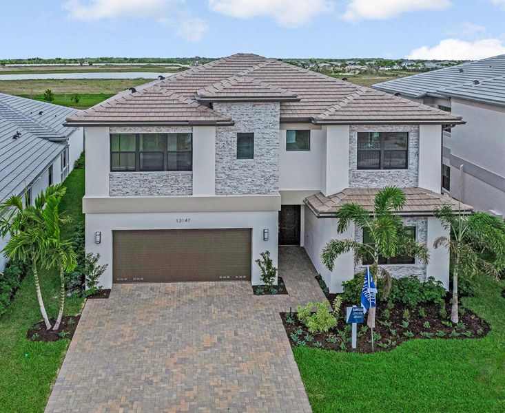 Front exterior of a new home in Apex at Avenir, Palm Beach Gardens, FL, highlighting curb appeal (Image 1).