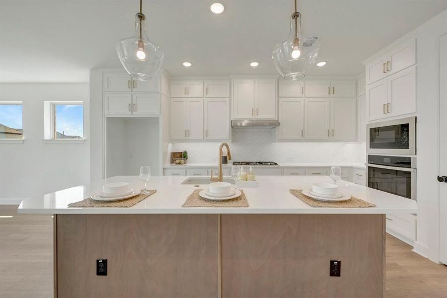 Kitchen island featuring a light wood-finish base and a white countertop