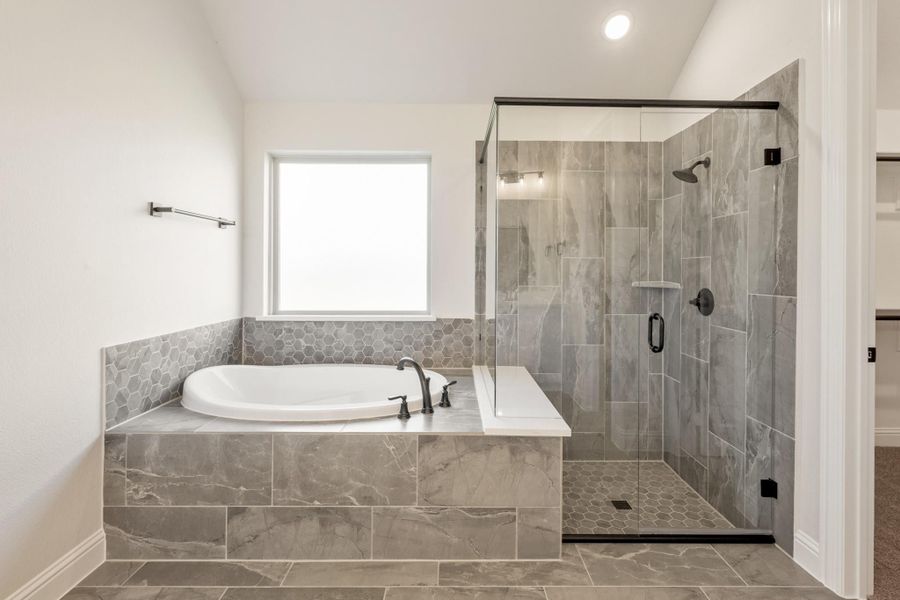 Master bathroom with soaking tub, glass walk-in shower, and gray marble tile surround