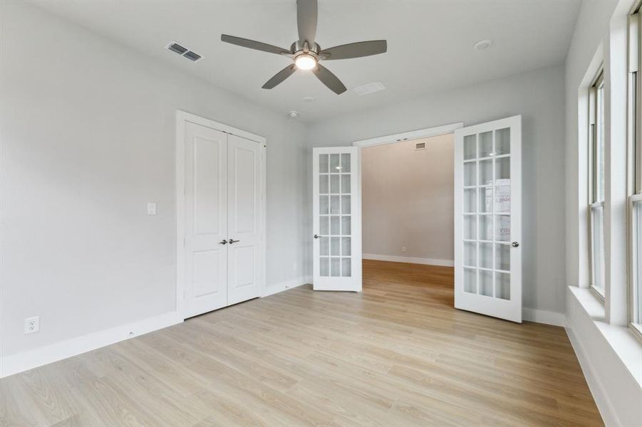 Unfurnished room featuring french doors, light wood finished floors, and a ceiling fan