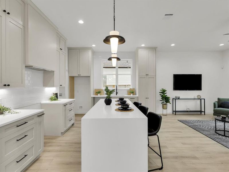 Kitchen featuring tasteful backsplash, white cabinetry, a center island, and light hardwood / wood-style floors