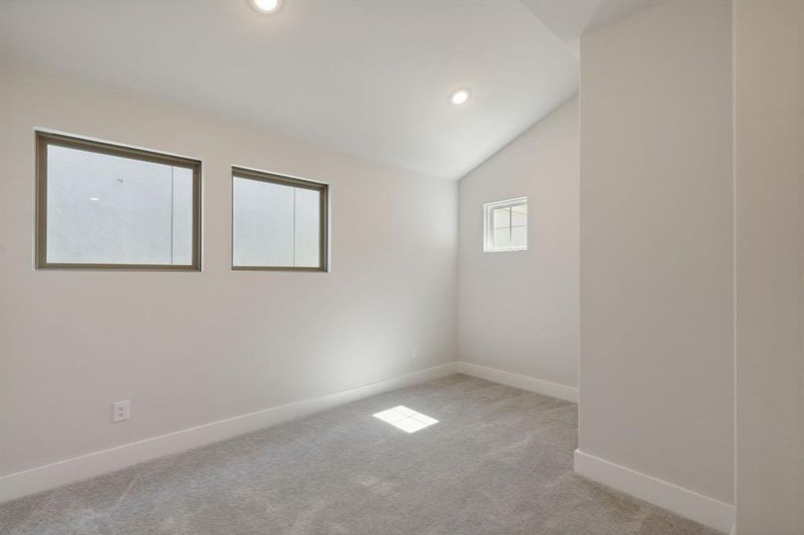 Unfurnished flex room with lofted ceiling, light colored carpet, baseboards, and recessed lighting