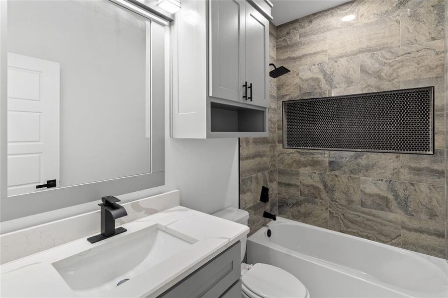 Full bathroom featuring tiled shower / bath, toilet, and vanity