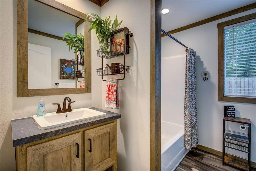 Hall bath has shower / tub combination, vanity, LVP flooring