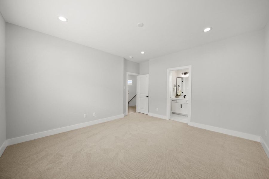 Another angle of the bedroom reveals a door on the right, leading to the ensuite bath. Another angle of the bedroom reveals a door on the right, leading to the ensuite bath.