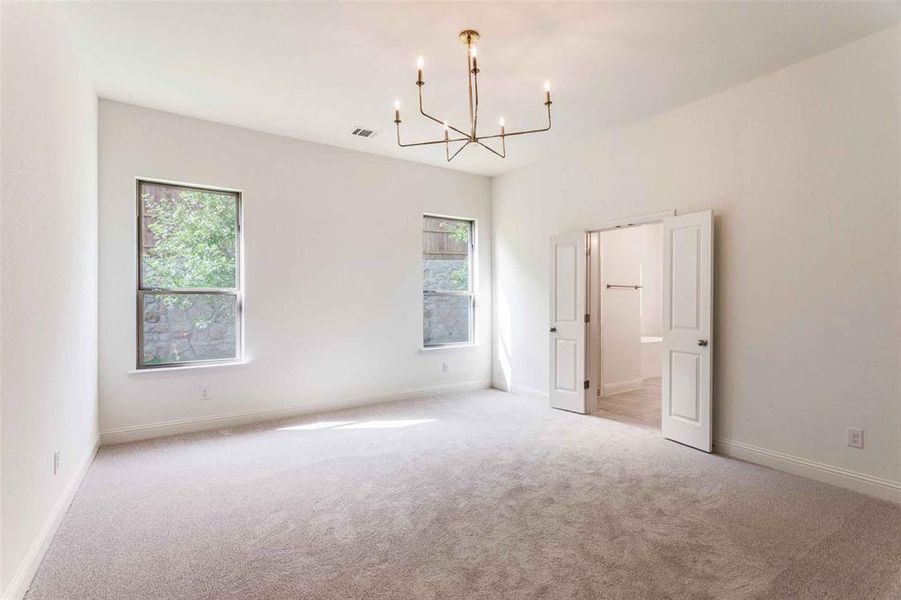 Spare room with a chandelier, light carpet, plenty of natural light, and baseboards Spare room with a chandelier, light carpet, plenty of natural light, and baseboards