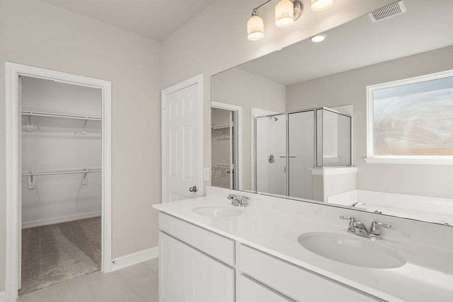 The en-suite bathroom offers a spa-like atmosphere with its elegant design, high end finishes, and tasteful lighting, creating a retreat within your own home.