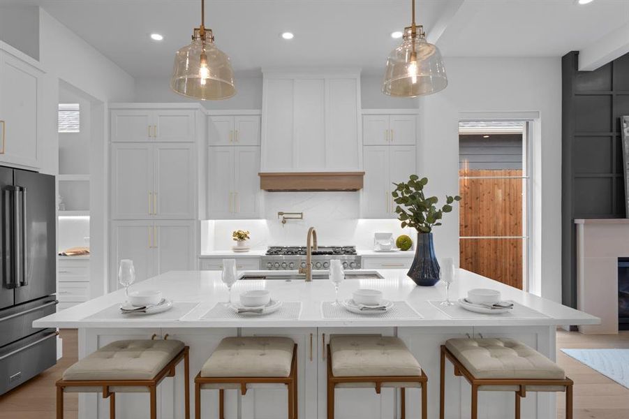 Kitchen featuring a breakfast bar area, Storage Galore, white cabinets, high end appliances, Pot Filler, 6 Gas 6 burners and a grill, farmhouse oversized sink, pendant lighting, and recessed lighting Kitchen featuring a breakfast bar area, Storage Galore, white cabinets, high end appliances, Pot Filler, 6 Gas 6 burners and a grill, farmhouse oversized sink, pendant lighting, and recessed lighting