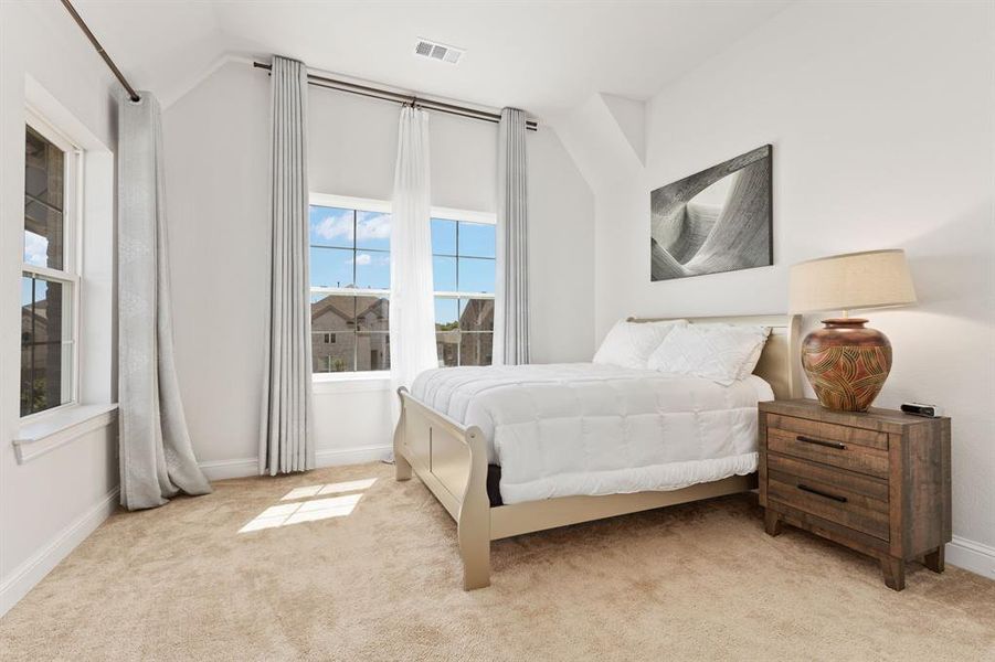 Bedroom featuring lofted ceiling and light carpet