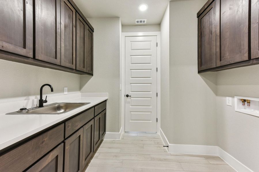Washroom featuring cabinet space, light wood-style flooring, and recessed lighting