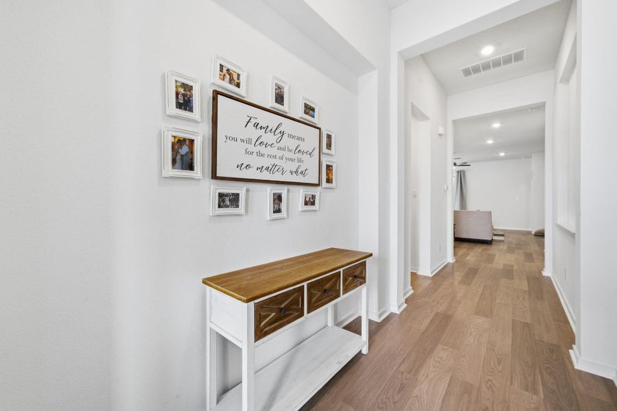 Corridor with light wood-type flooring and recessed lighting