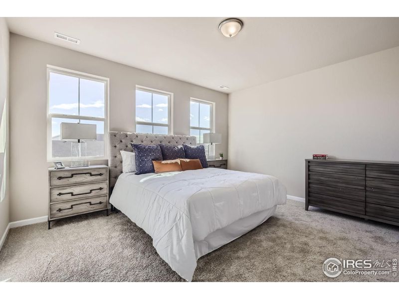 Primary bedroom *Photo not of actual home, but same floorplan and style*