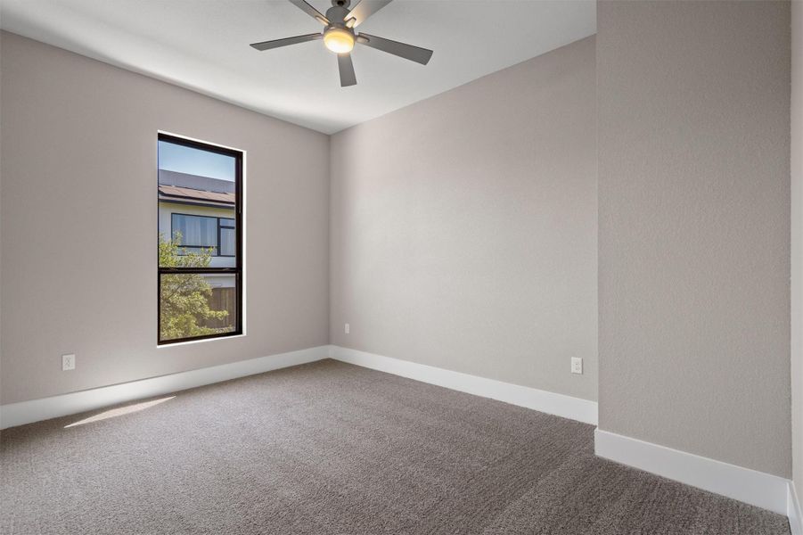 A quiet bedroom offering comfort, with an overhead ceiling fan and a view to the outside. A quiet bedroom offering comfort, with an overhead ceiling fan and a view to the outside.