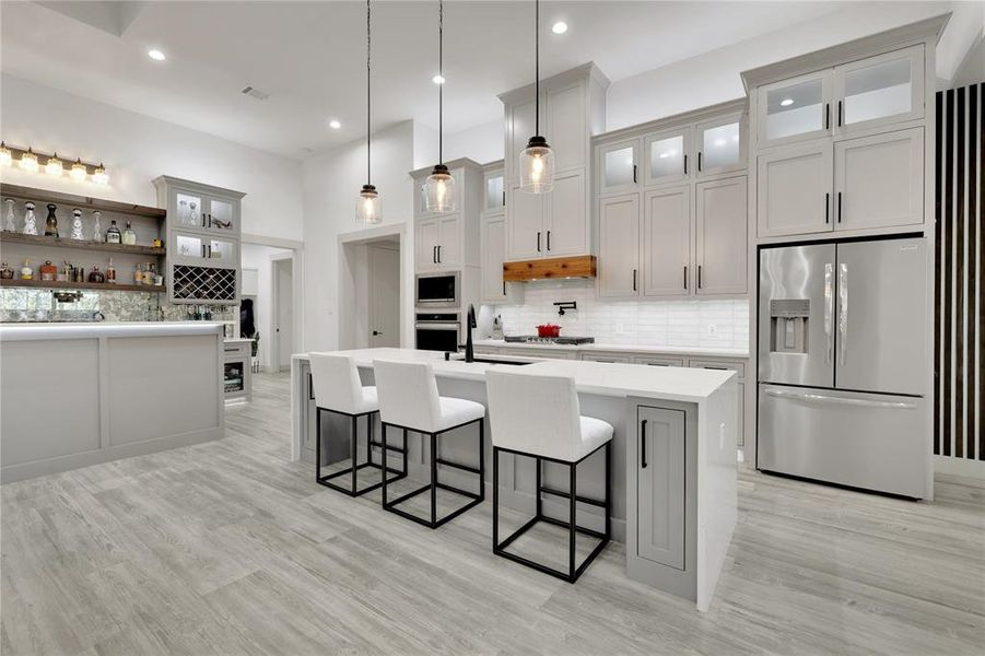 Additional seating and storage in this island. Love the drop pendant lighting. Pantry is located to the left of the oven in that hallway.