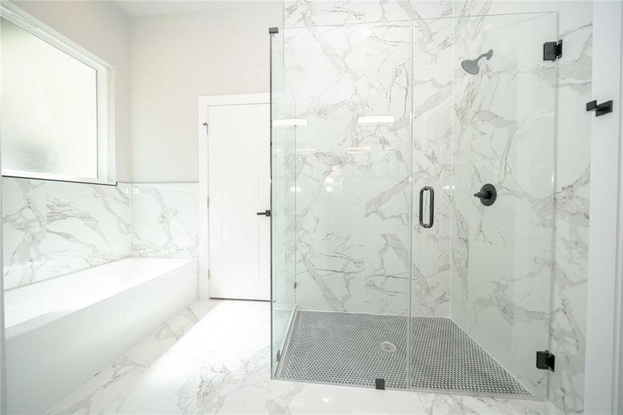Bathroom with a bath, marble finish floors, a marble finish shower, tile walls, and a wainscoted wall Bathroom with a bath, marble finish floors, a marble finish shower, tile walls, and a wainscoted wall