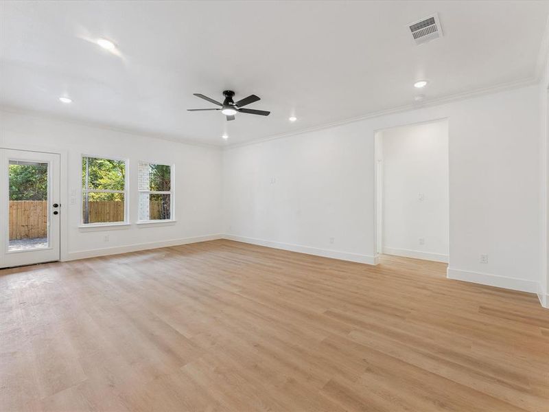 Empty room with light wood finished floors, crown molding, recessed lighting, and a ceiling fan