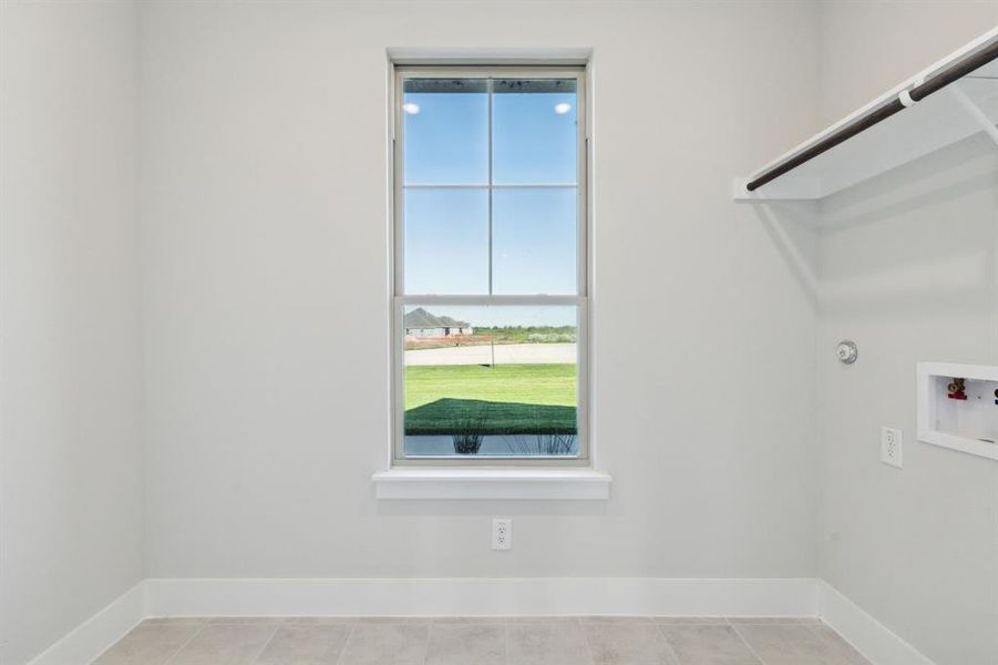 Washroom featuring washer hookup and light tile patterned floors