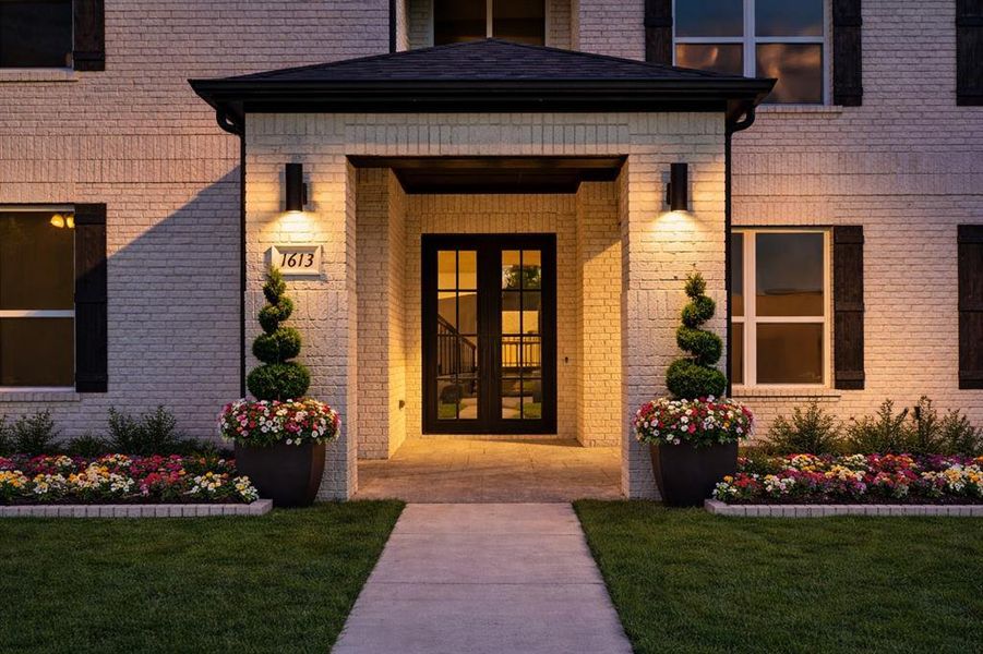 Property entrance with french doors, brick siding, and a yard