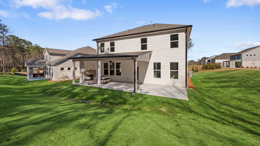 Rear exterior of home with covered patio, ceiling fan, and fireplace Rear exterior of home with covered patio, ceiling fan, and fireplace