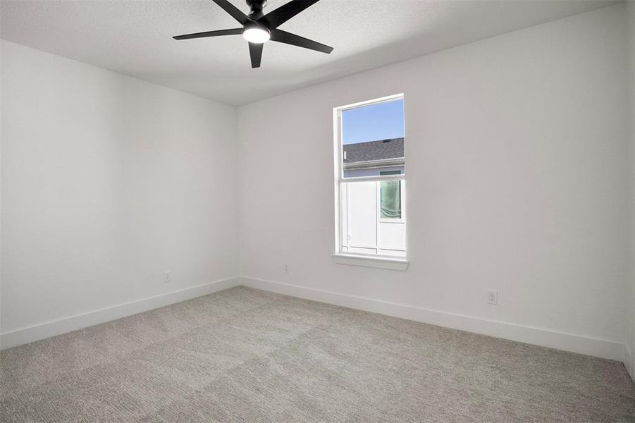 Spare room with light carpet and ceiling fan