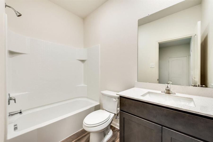 Full bathroom featuring vanity, shower / washtub combination, wood-style flooring, and toilet