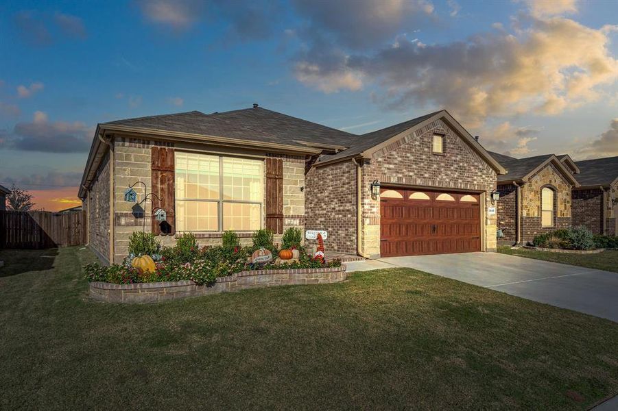 View of front of home featuring a garage and a yard