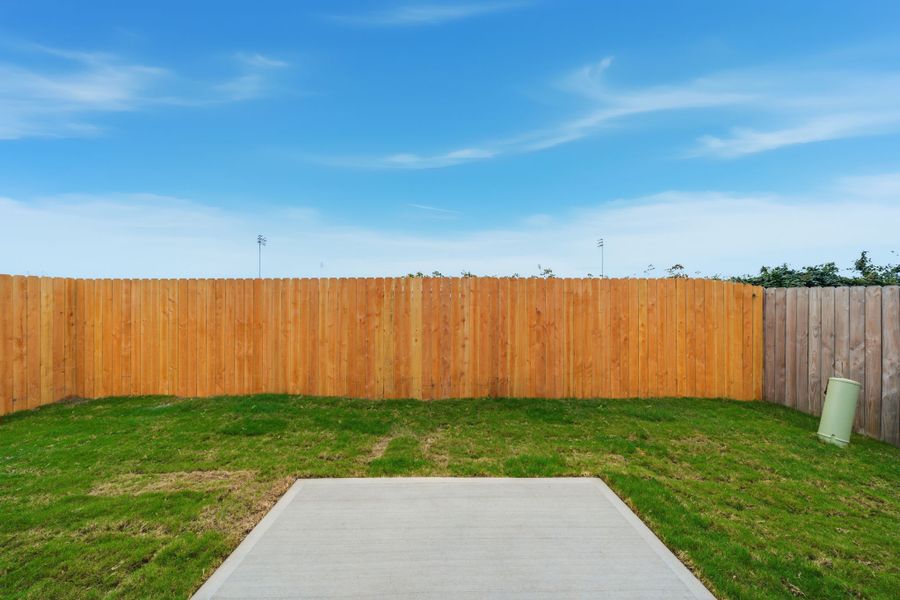 A fenced in yard with a white table and a wood fence. A fenced in yard with a white table and a wood fence.