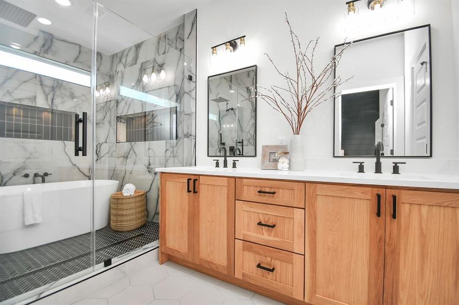 Exquisite primary bath featuring dual vanity sinks, soaking tub, walk in shower, and modern finishes.