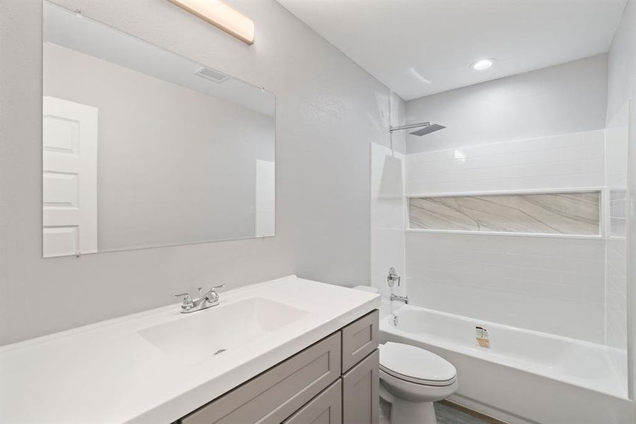 Full bathroom featuring vanity, washtub / shower combination, and toilet