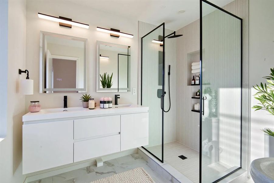 Bathroom with double vanity, a shower stall, and light marble finish flooring