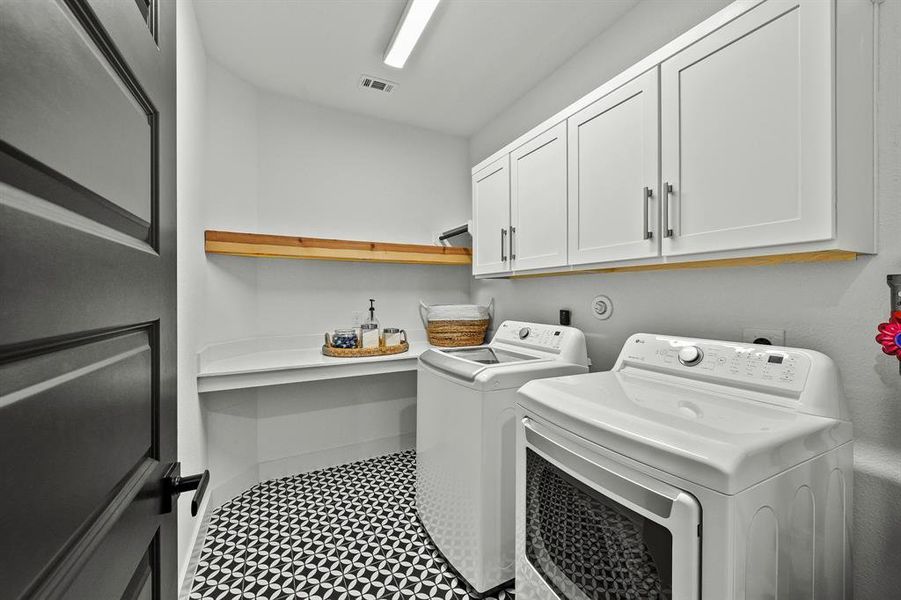 Laundry room with folding counter and storage cabinets.