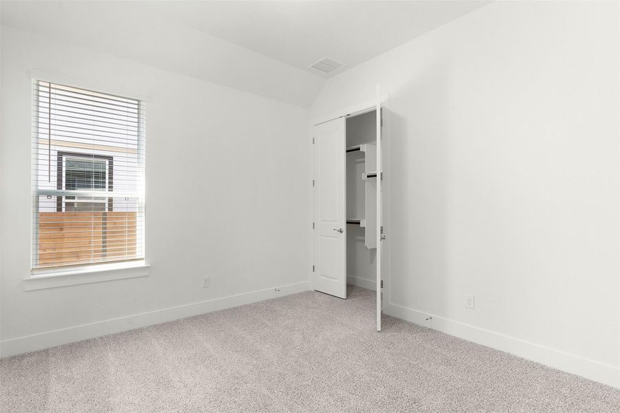 Unfurnished bedroom with light carpet and a closet