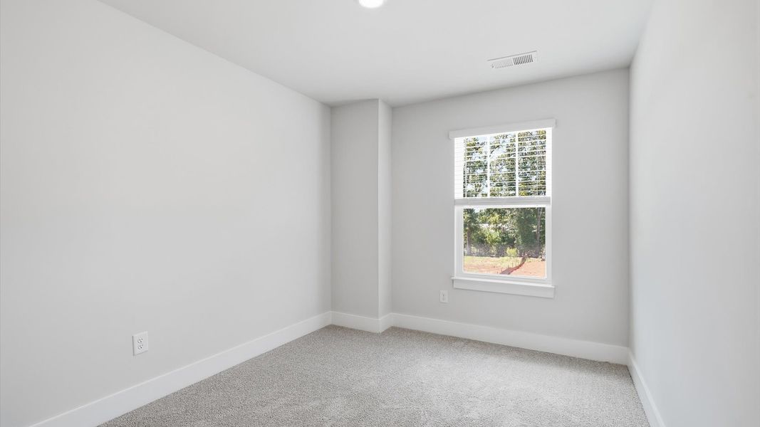 Bright and serene bedroom with comfortable carpeted flooring and a large window for vibrant light near Lake Hartwell Bright and serene bedroom with comfortable carpeted flooring and a large window for vibrant light near Lake Hartwell