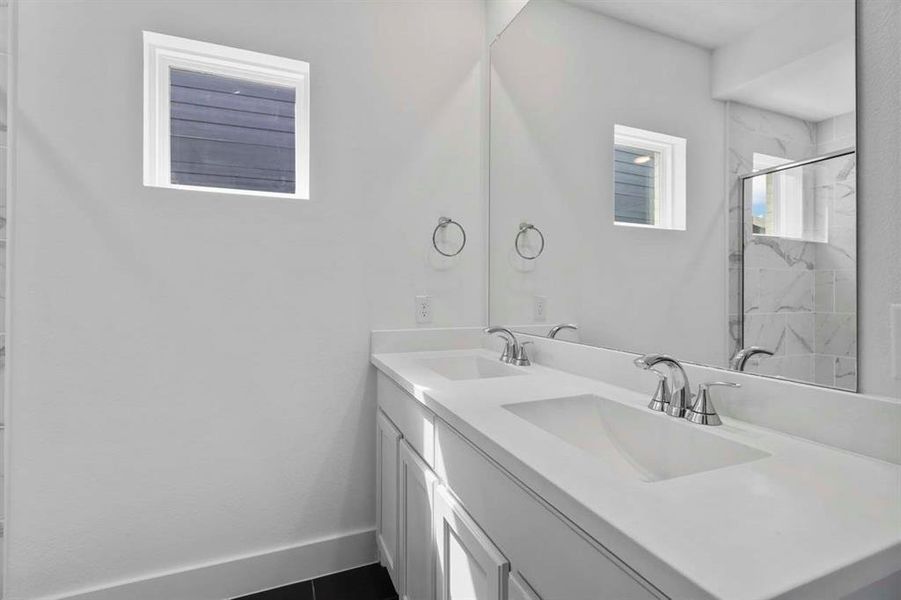 Bathroom featuring double vanity and a marble finish shower Bathroom featuring double vanity and a marble finish shower