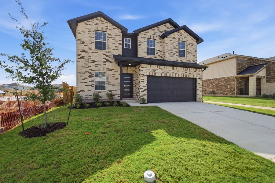 Front exterior of a new home in Sunfield, Buda, TX, highlighting curb appeal (Image 2).