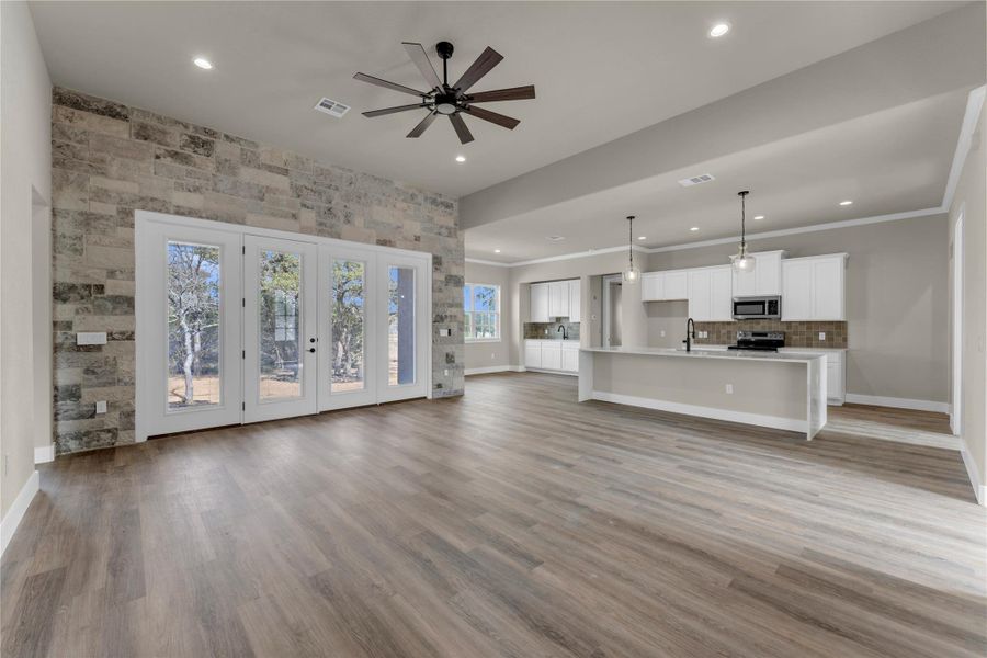 Unfurnished living room with a ceiling fan, recessed lighting, light wood-style flooring, and ornamental molding