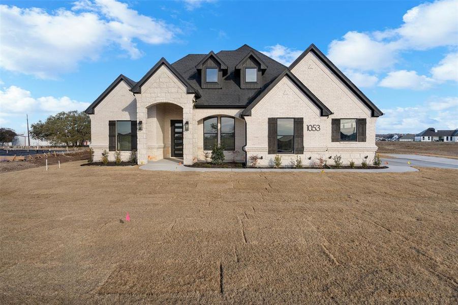 French country inspired facade featuring a front yard