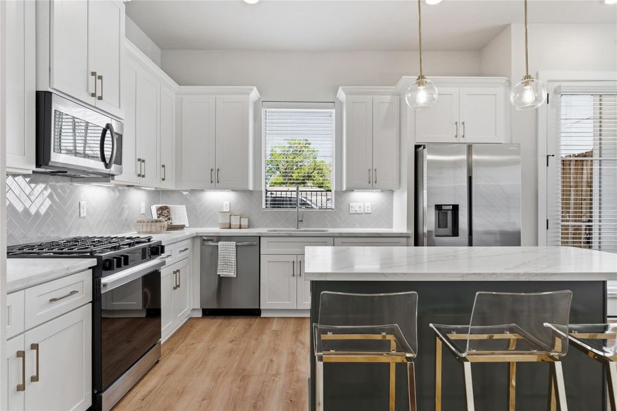 Subtle design accents like brass hardware and pendant lighting add warmth and contrast to the clean cabinetry and neutral palette. Subtle design accents like brass hardware and pendant lighting add warmth and contrast to the clean cabinetry and neutral palette.