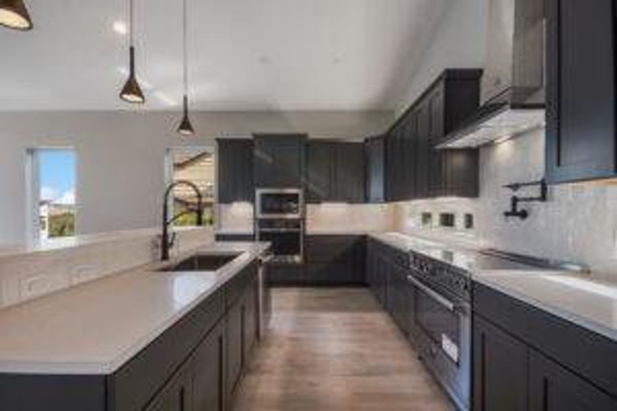 Kitchen featuring a sink, stainless steel appliances, a healthy amount of sunlight, and light countertops