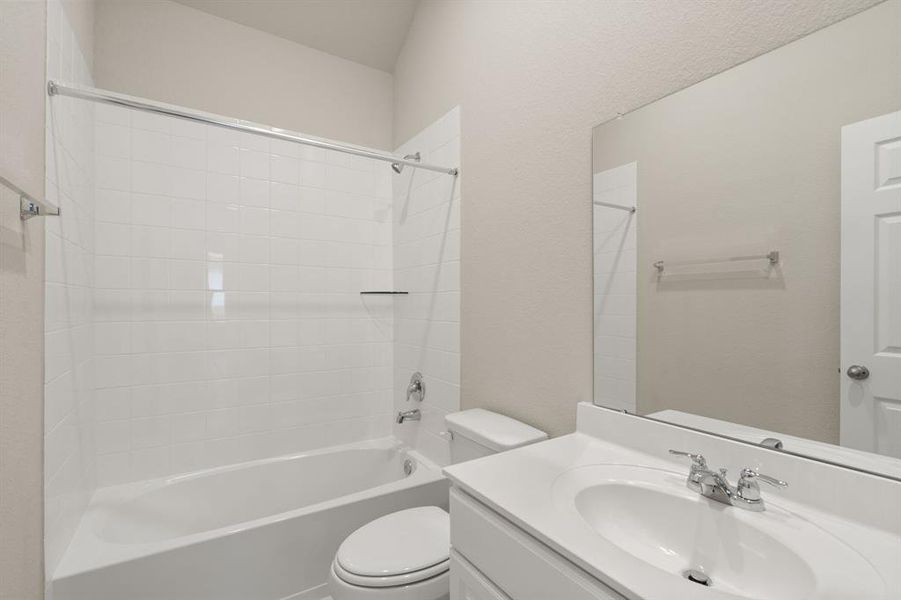 The secondary bath features tile flooring, white cabinetry and light countertops and a shower/tub combo. Perfect for accommodating any visiting family and friends.