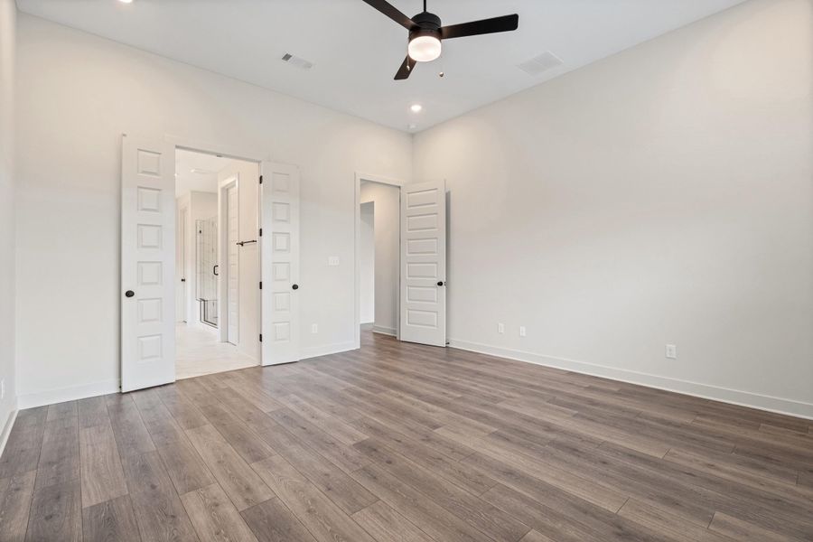 Spacious room with wood-finish flooring, recessed lighting, and a ceiling fan Spacious room with wood-finish flooring, recessed lighting, and a ceiling fan