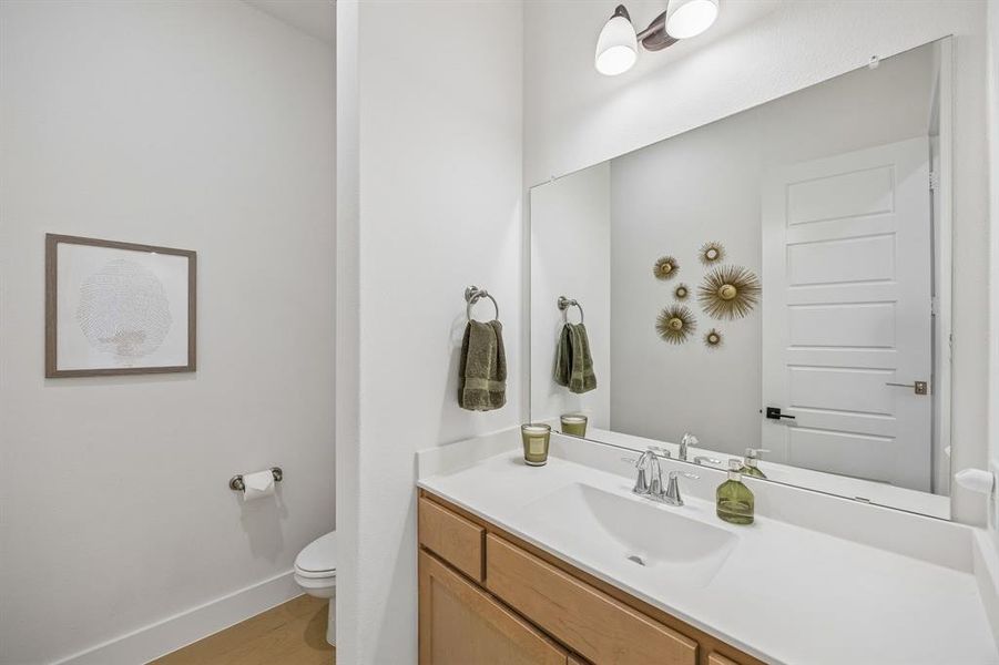 Half bath with vanity and light wood-type flooring