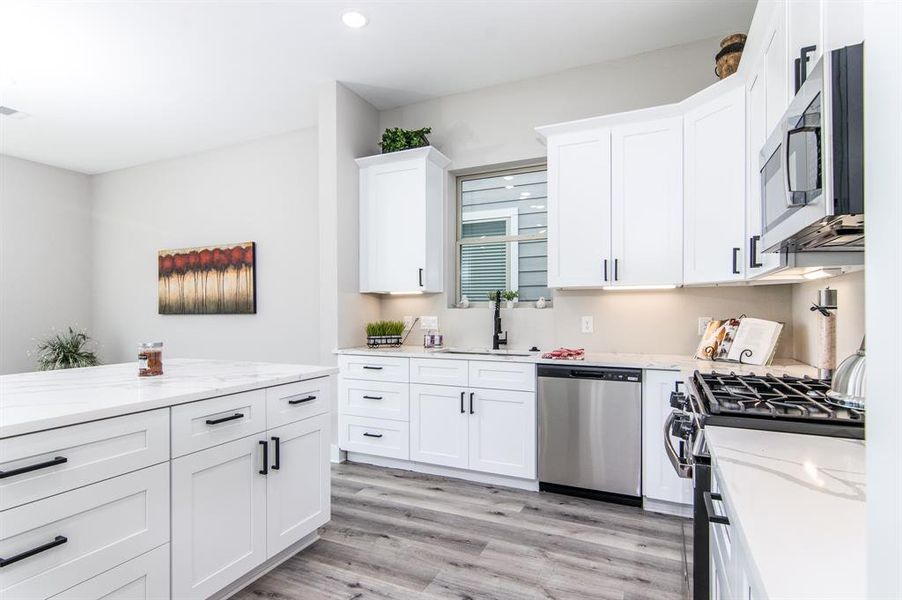 The kitchen has elegant calacatta quartz, under cabinet lighting, soft close drawers and cabinet doors.