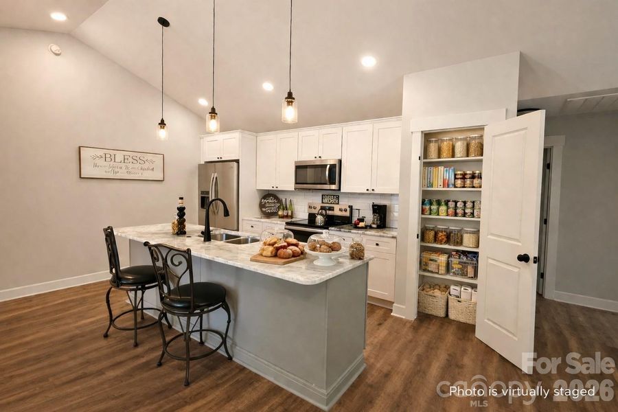 Virtually staged Gourmet Kitchen with marble counters & oversize island & two Pantries. (The refrigerator is virtually staged. Home comes with stove, dishwasher & microwave.) The Kitchen is also actually staged some.)