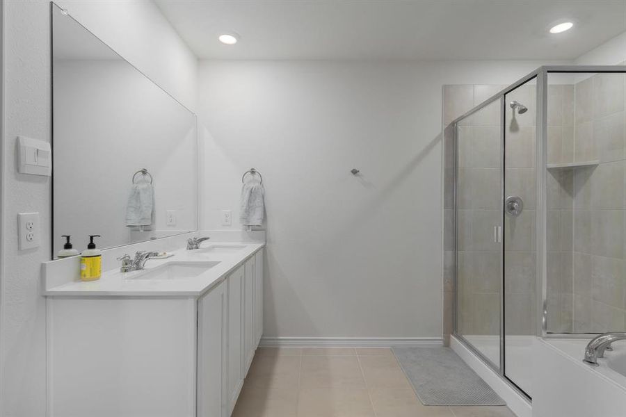 Bathroom with a stall shower, a sink, baseboards, and tile patterned floors